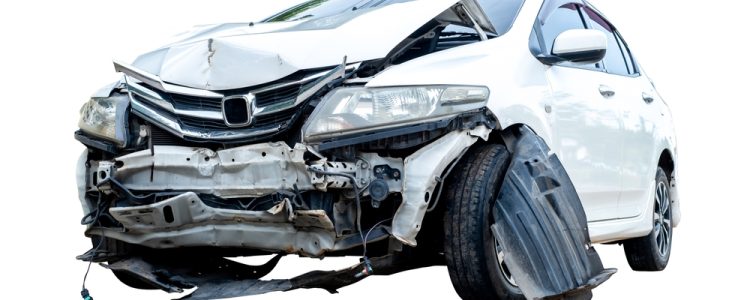 Front view of a white car with significant damage to the bumper and hood after an accident