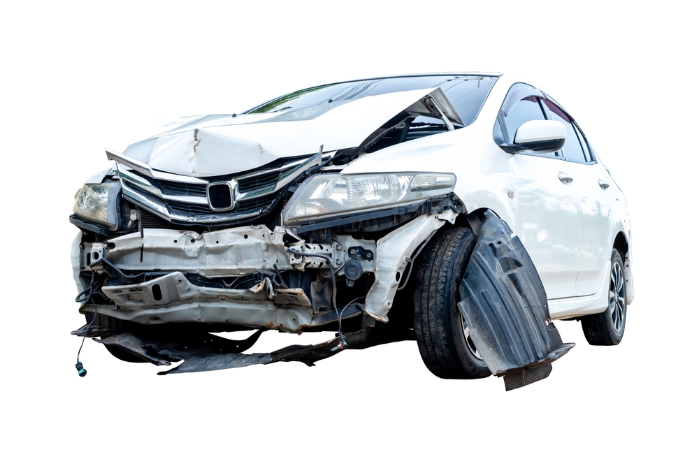 Front view of a white car with significant damage to the bumper and hood after an accident