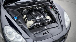 Open hood view of a modern car engine bay showing various components and fluid reservoirs