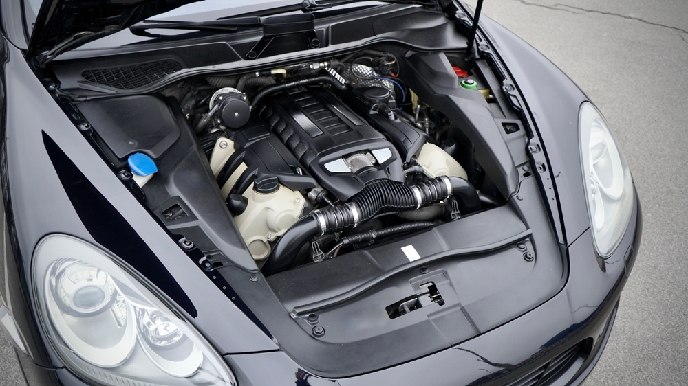 Open hood view of a modern car engine bay showing various components and fluid reservoirs